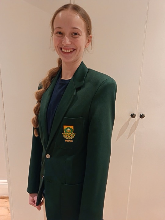 Vivienne van der Schyff smiling in her green South Africa Squash blazer
